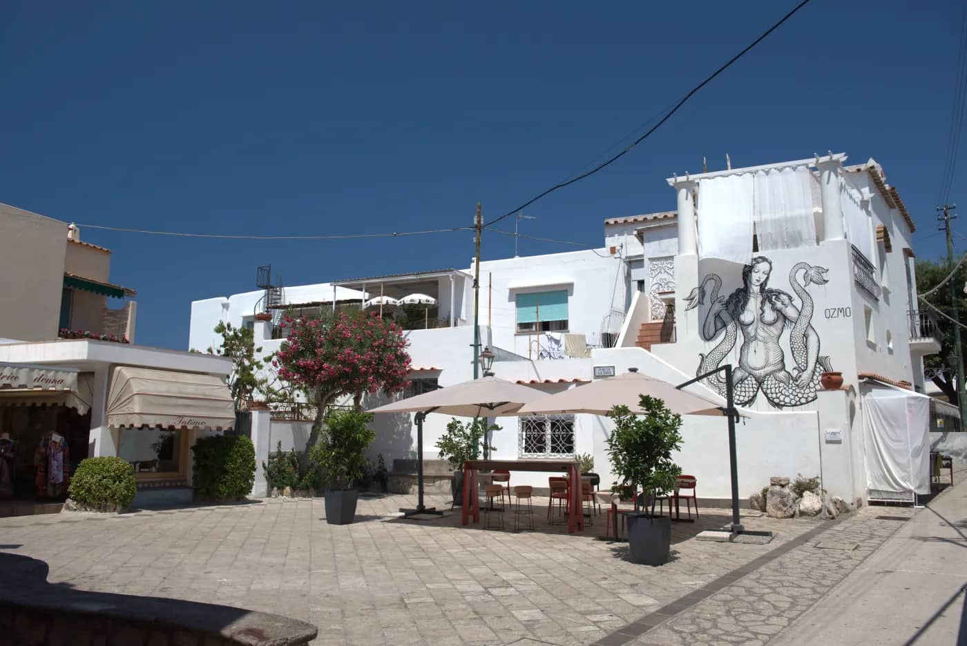 a courtyard with building that has an artistic rendering of a mermaid