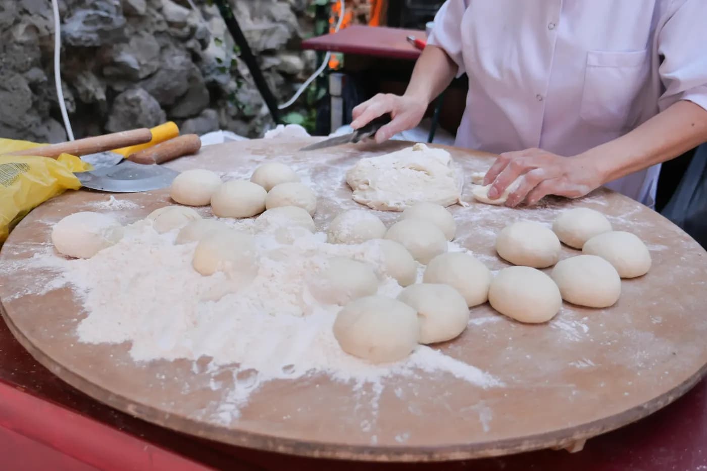 Close up of a person's hands while preparing pizza dough