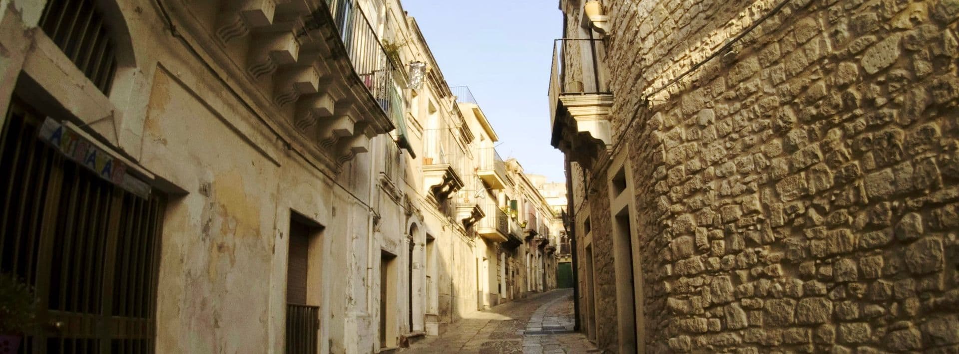 narrow street between baroque buildings in Ragusa, Italy