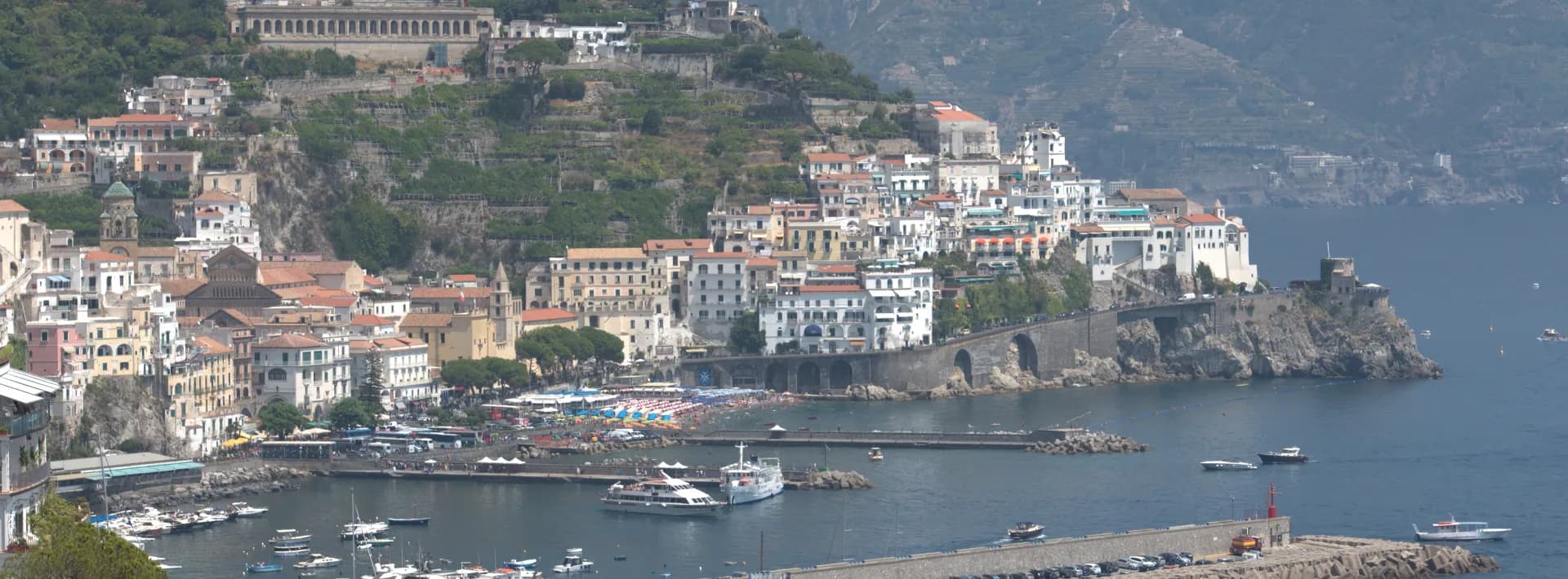 view of a marina and houses built upon the cliffside on the Amalfi Coast