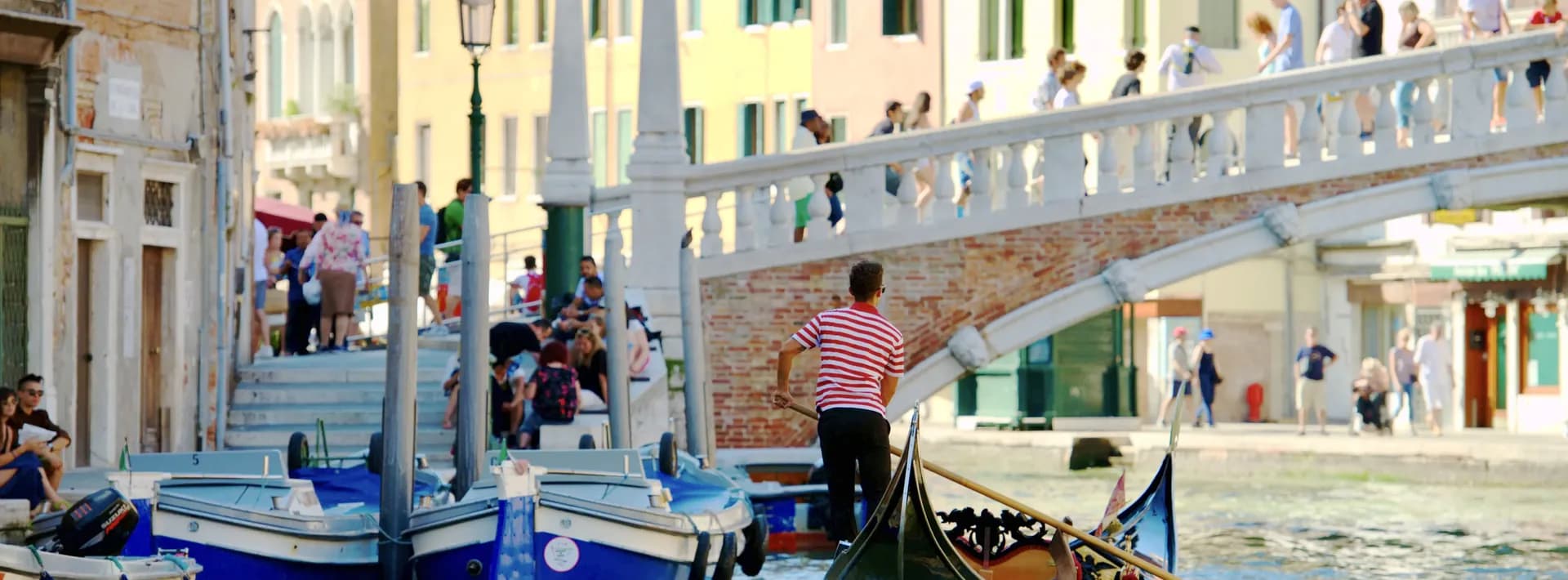 A gondola gliding along the Grand Canal in Venice, Italy before passing under a bridge.