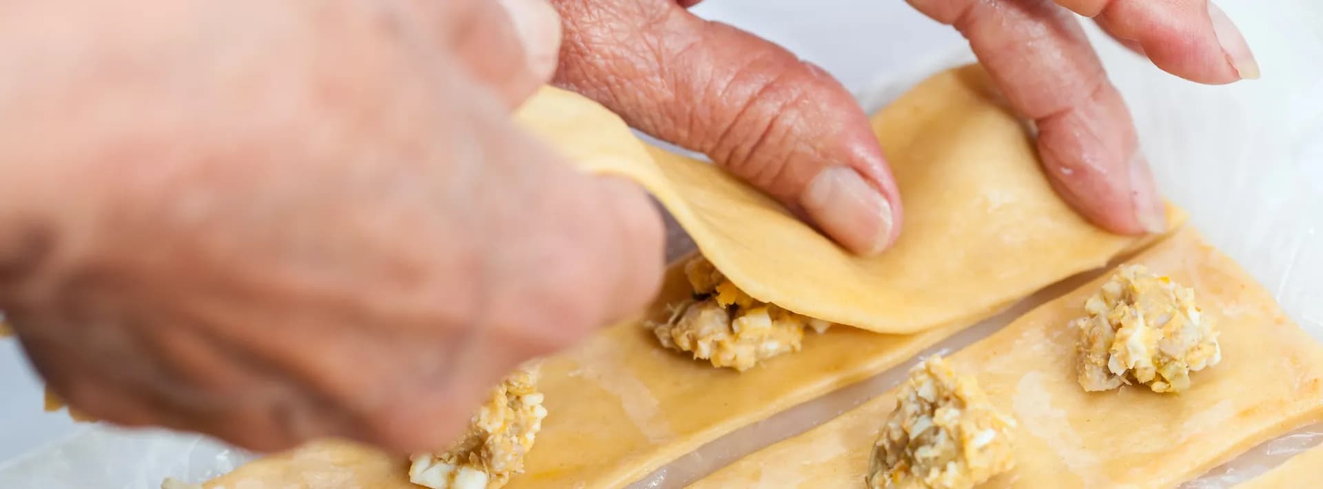 detail of a chef's hands preparing fresh ravioli