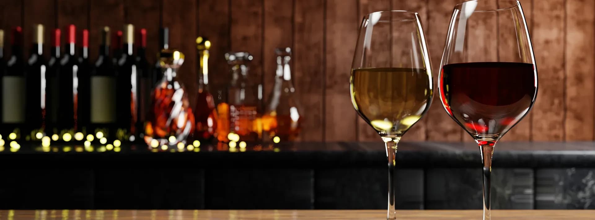 glasses of red and white wine with whiskey and brandi bottles in the background