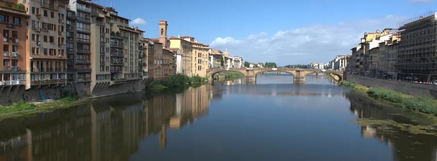 wide angle image of the Ponte Santa Trinita with buildings reflected in the Arno River