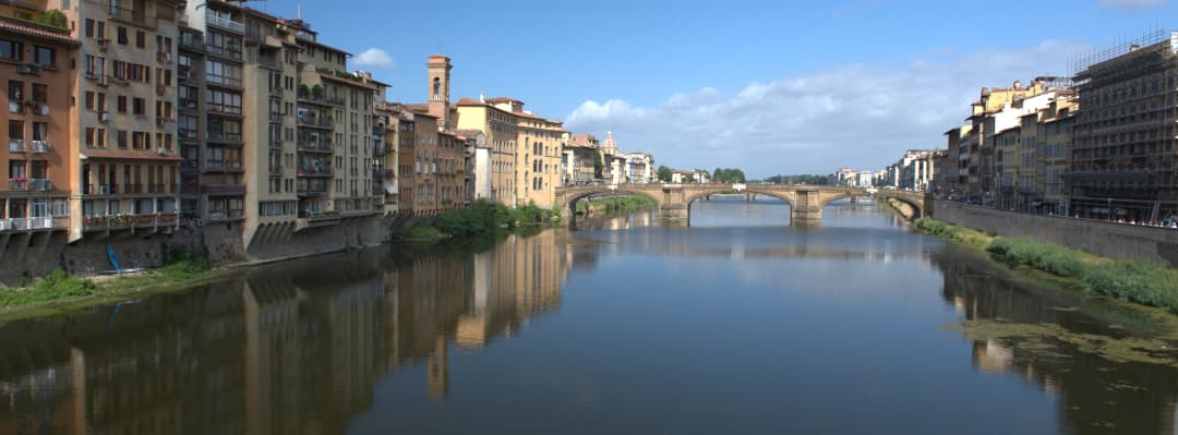 wide angle image of the Ponte Santa Trinita with buildings reflected in the Arno River
